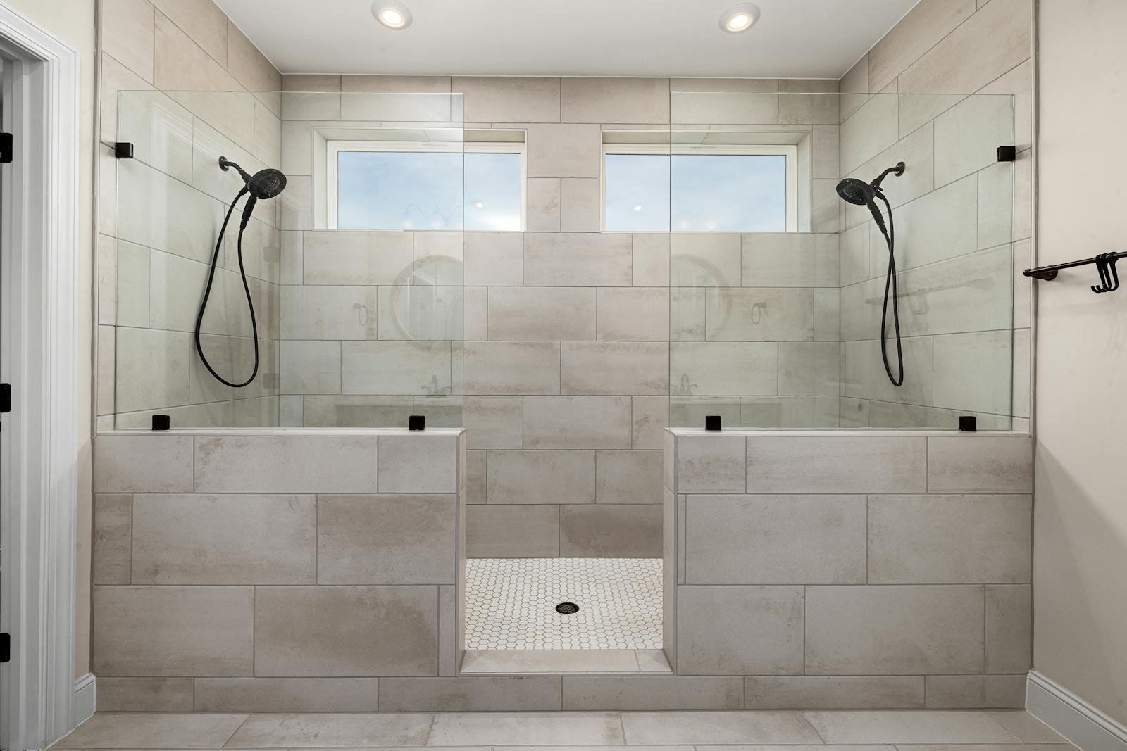 A contemporary bathroom shower with tile work and modern fixtures.