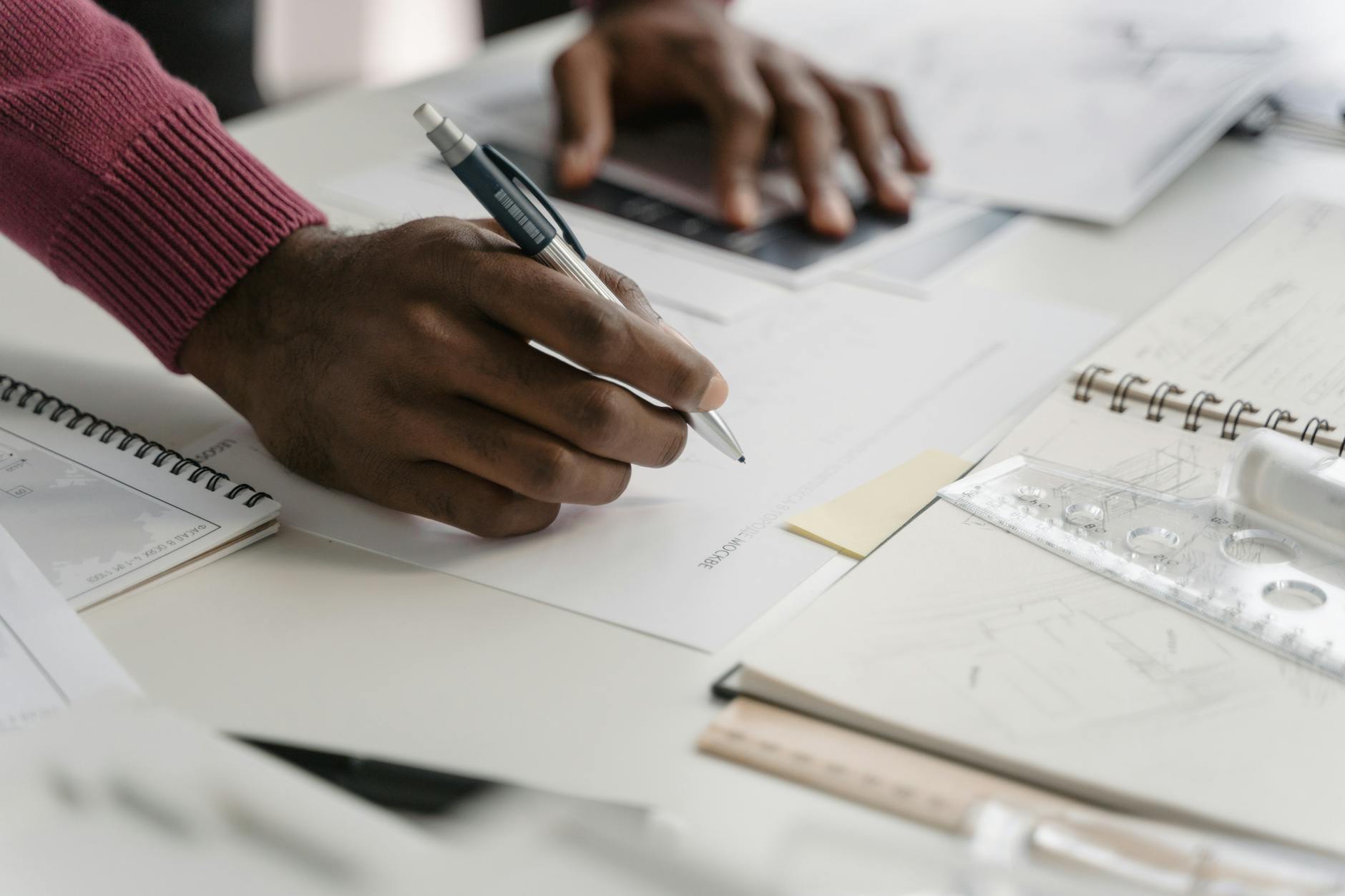 Close-up of a person reviewing construction plans before a remodeling estimate.