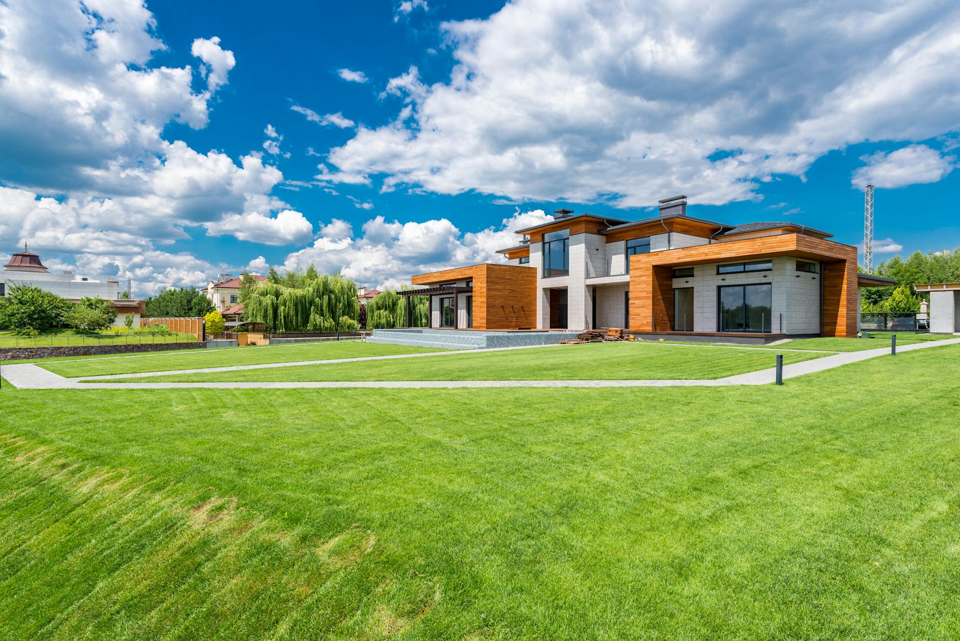 Exterior home renovation reference with wood siding, grass, and clear sky.