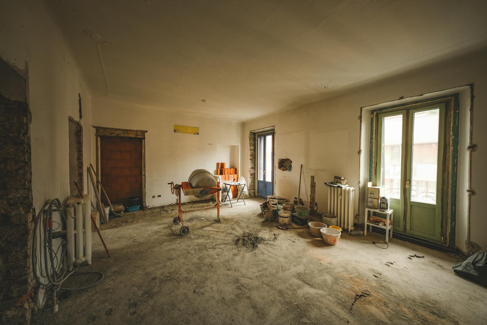 A sunlit interior room under renovation with construction materials.