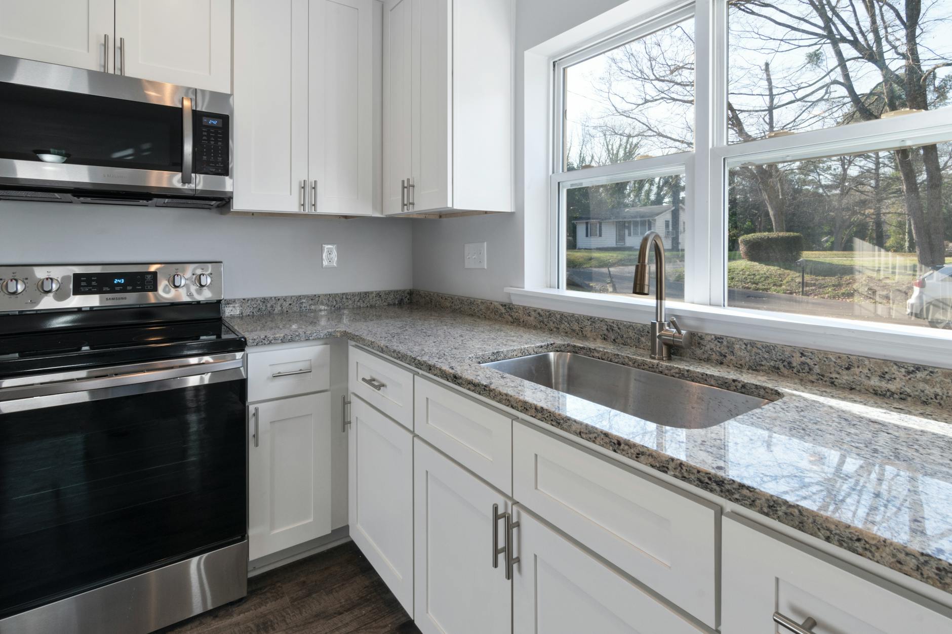 Bright kitchen remodeling reference with counters, appliances, and large windows.