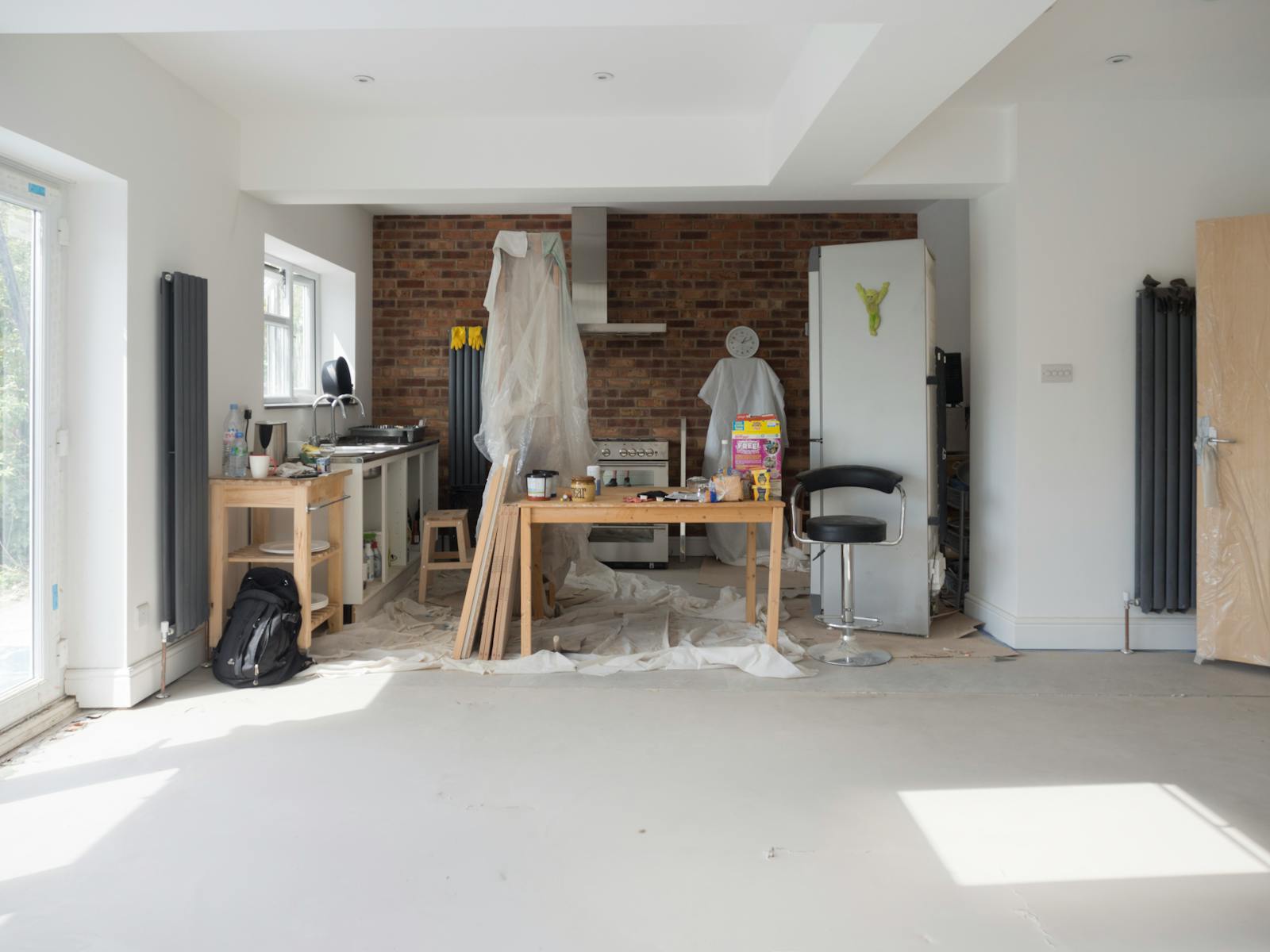A bright kitchen renovation in progress with tools and materials.