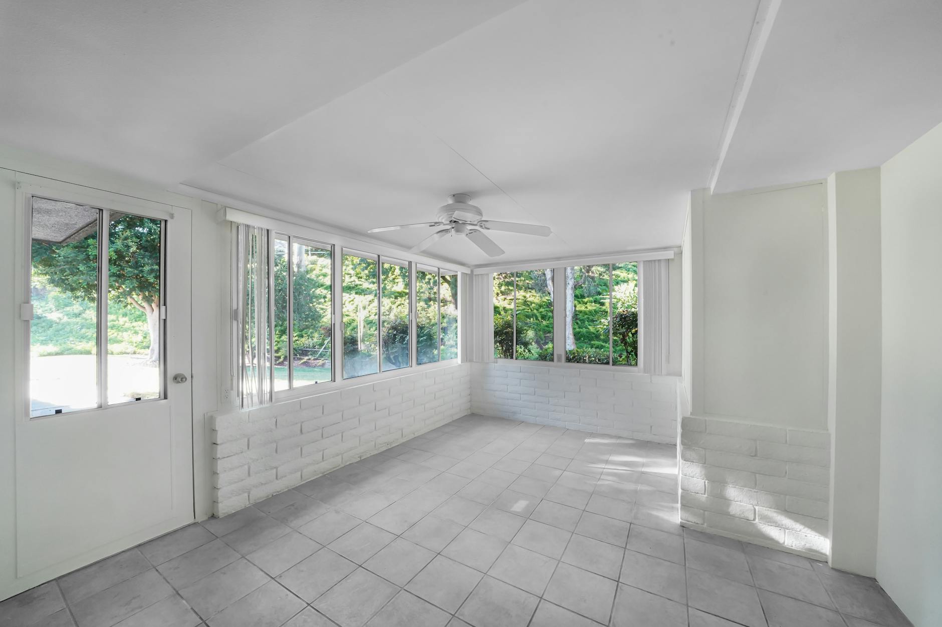 Sunroom addition reference with large windows, tiled floor, and natural light.